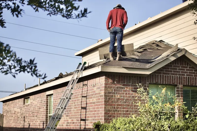 Professional roofer working on a residential roof in Schick